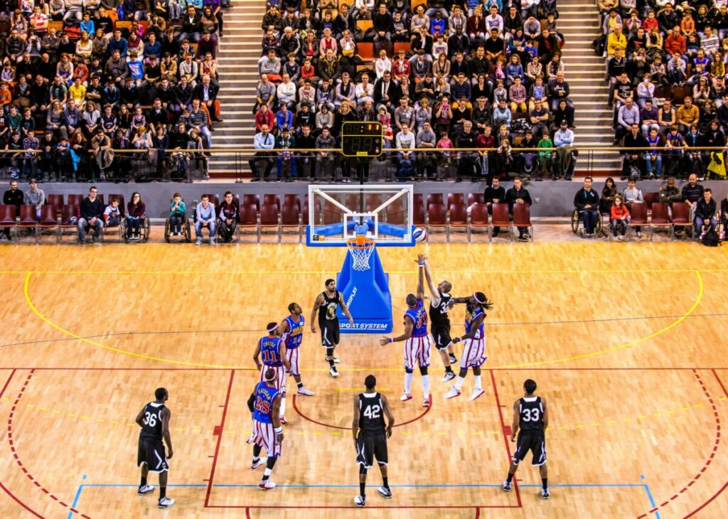 Match de basket-ball avec des joueurs en pleine action devant un public enthousiaste.