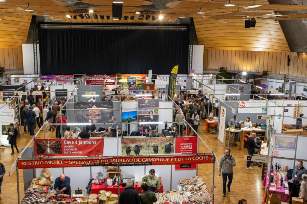 Foire alimentaire animée avec des exposants et des visiteurs interagissant autour des stands.