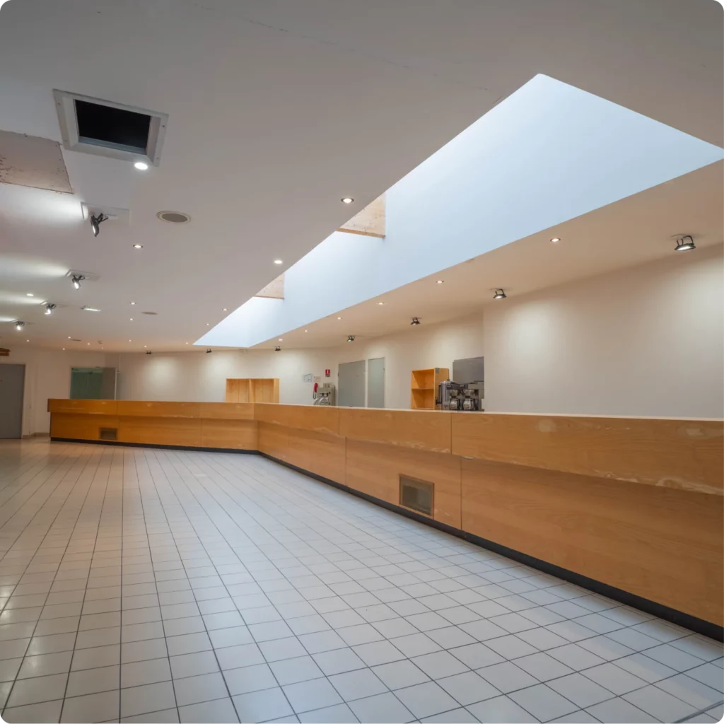 Espace intérieur lumineux avec un comptoir en bois et des zones de service.